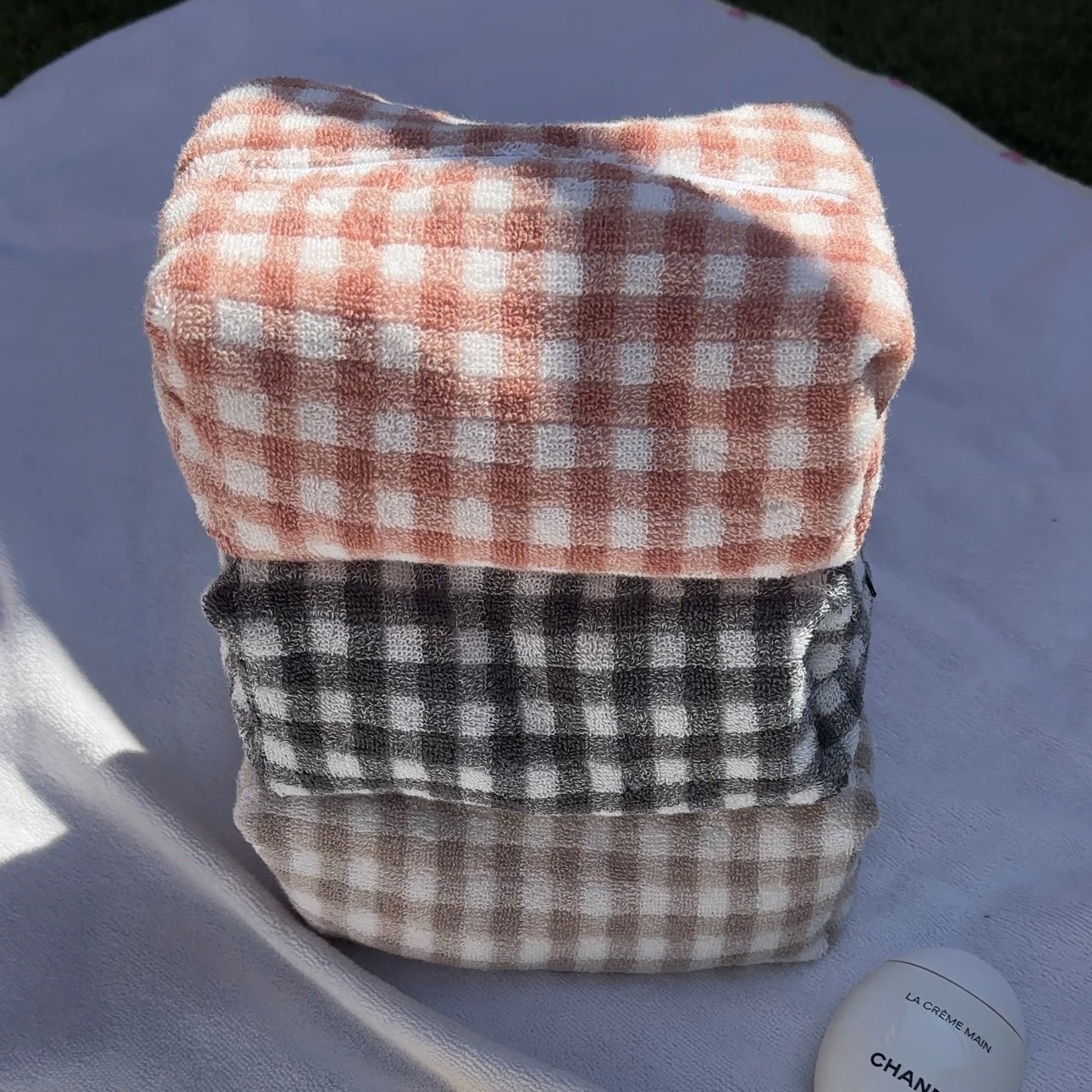 Folded gingham cloth set: red-orange and white gingham top, black gingham bottom.