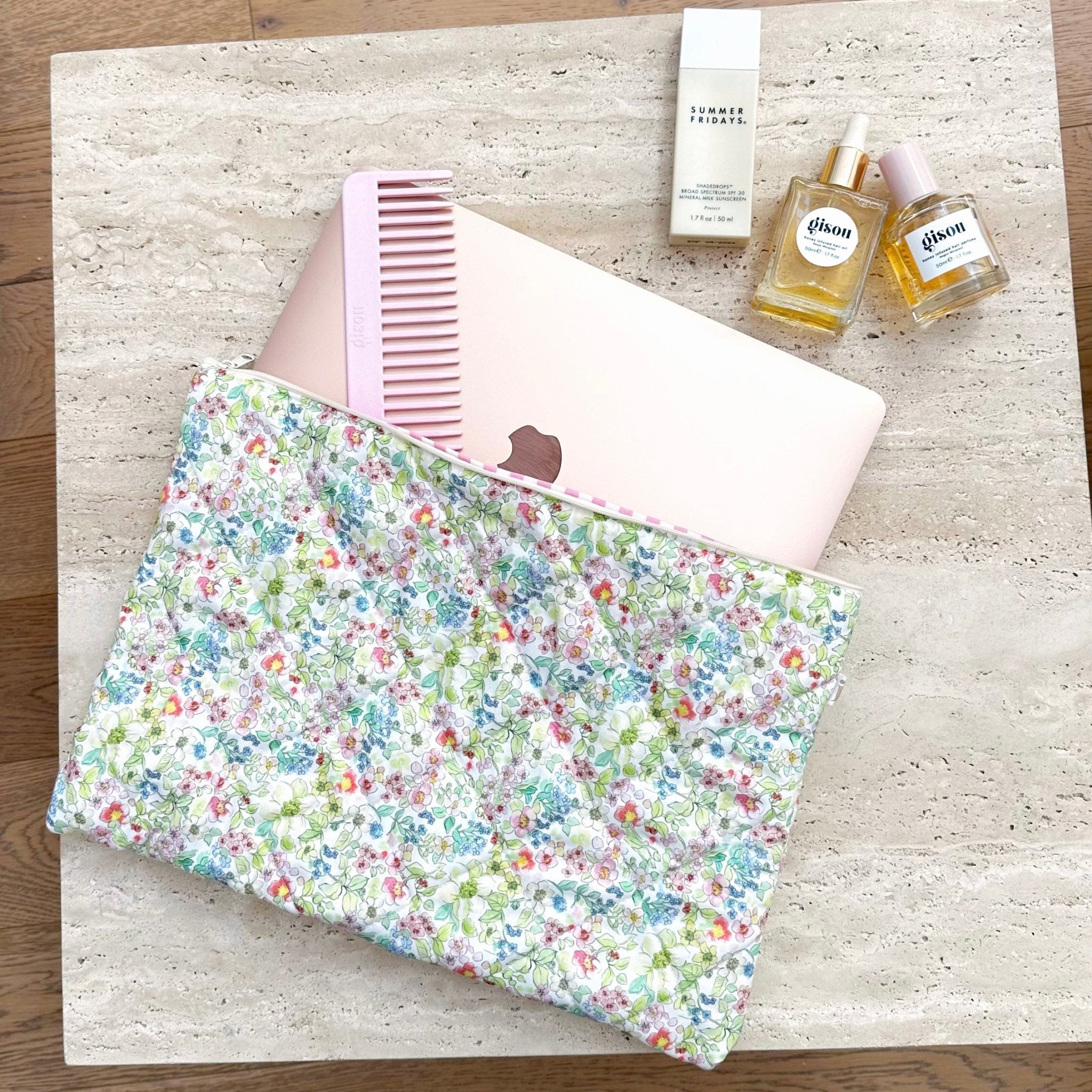 Floral zip pouch laid flat with green, blue, and pink flower print and pink gingham lining
