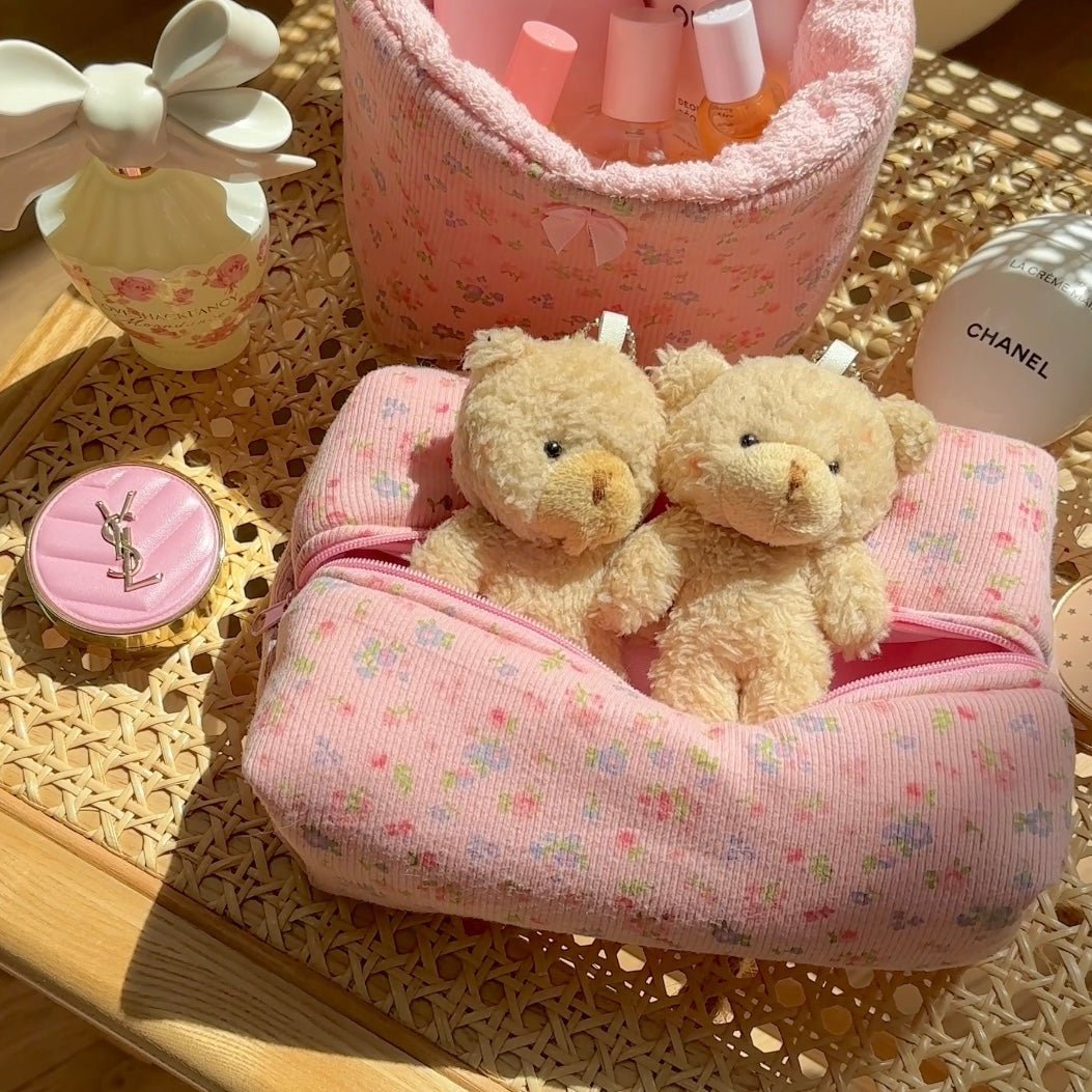 Pink floral-patterned cushion bag detail with two small teddy bears
