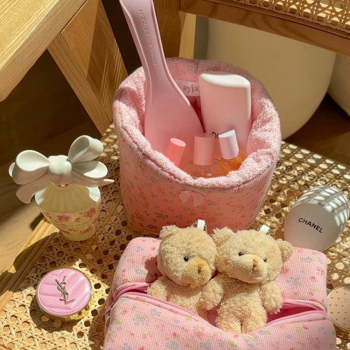 Pink floral organizer basket with soft terry lining and open top holding bottles and plush