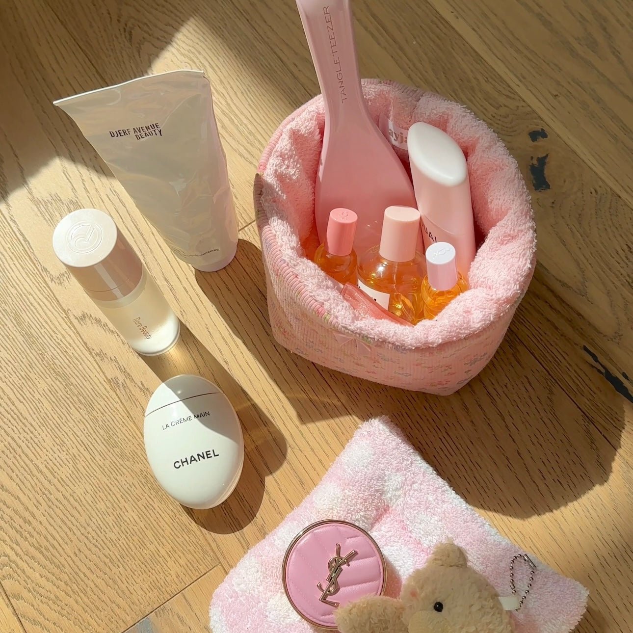 Pink floral organizer basket with fuzzy lining and open top holding small beauty bottles