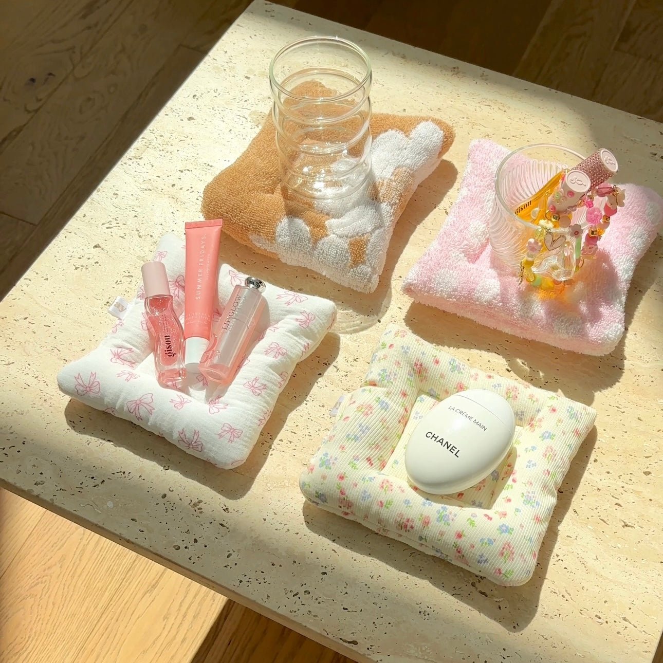Four cloud coasters in yellow, pink, white floral, and light multicolor with items