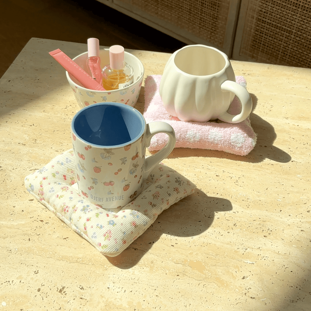 Blue and pink mugs on floral and pink cloud coasters