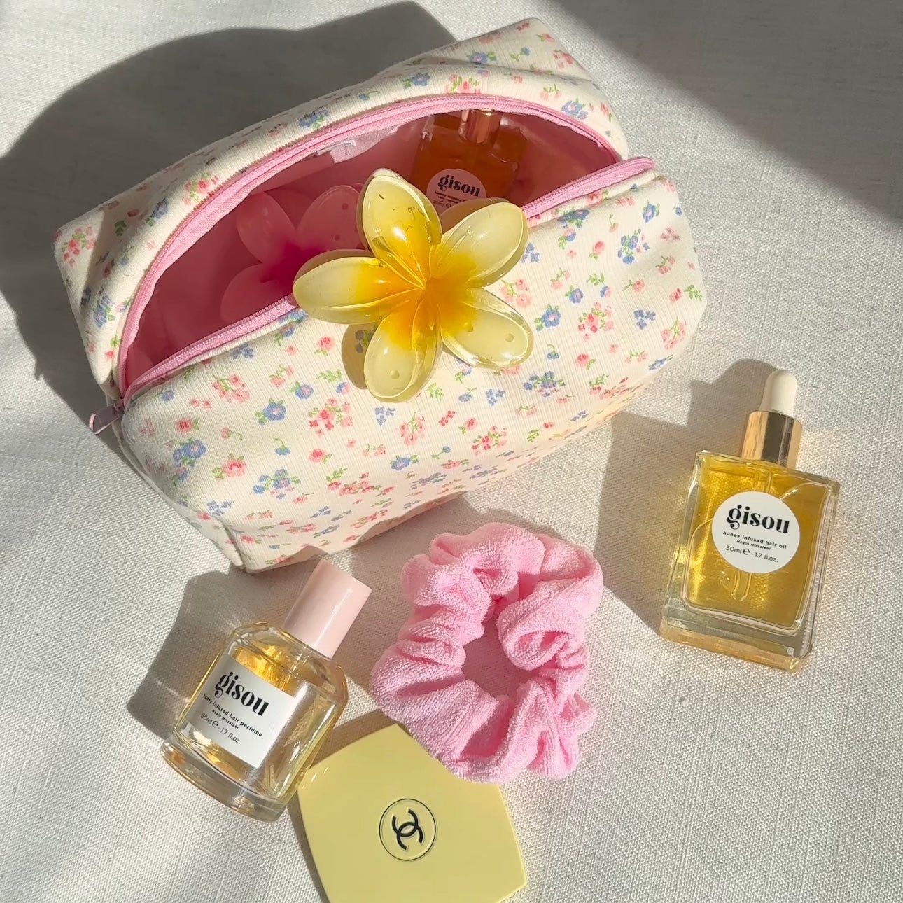 Cream floral pouch with pink zipper, yellow flower charm on top