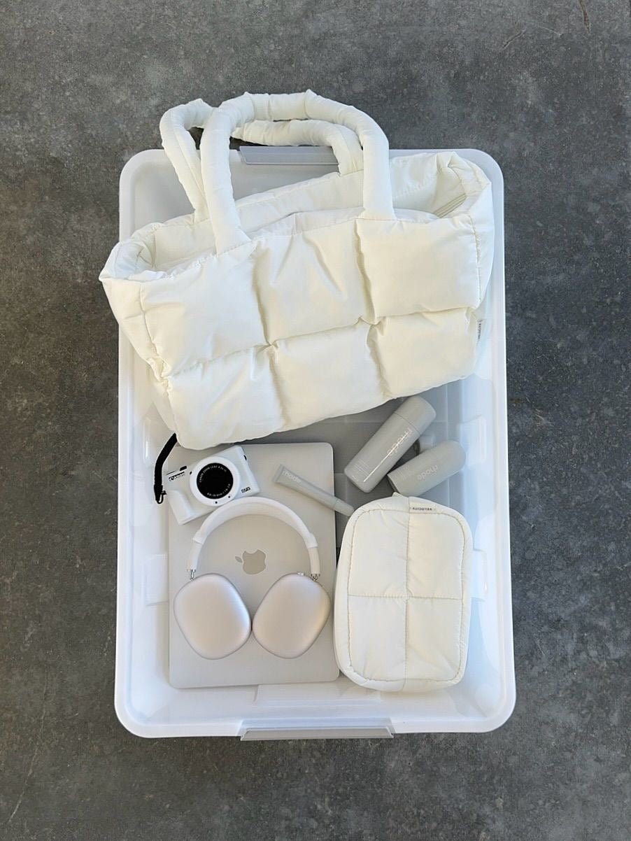 White quilted puffer duffle bag laid flat with contents inside