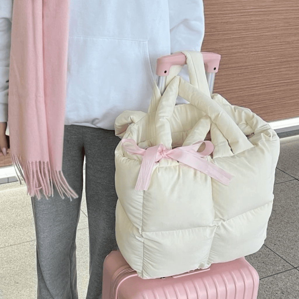 Cream puffer tote bag with top handles and pink bow ribbon detail