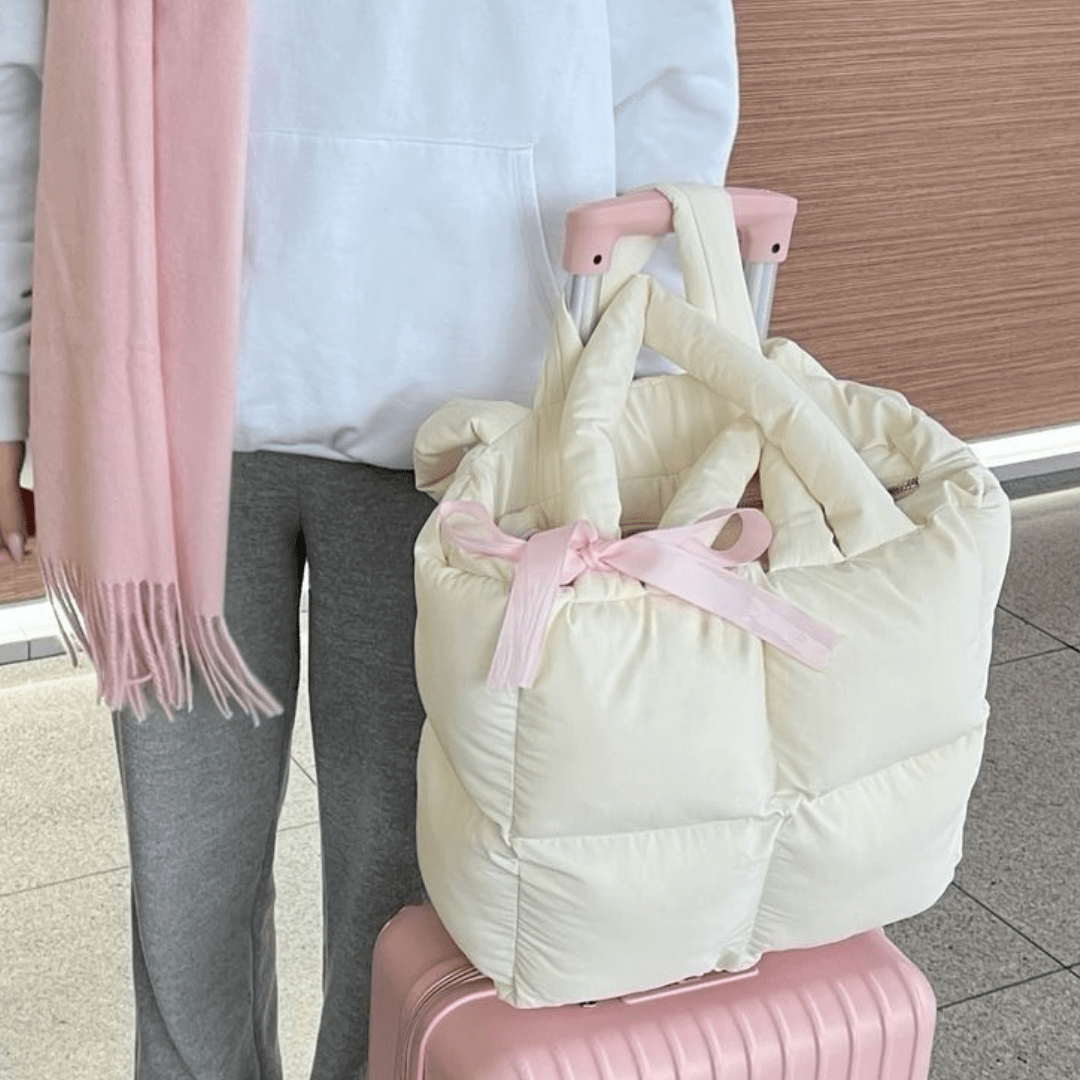 Cream puffer tote bag with top handles and pink bow ribbon detail