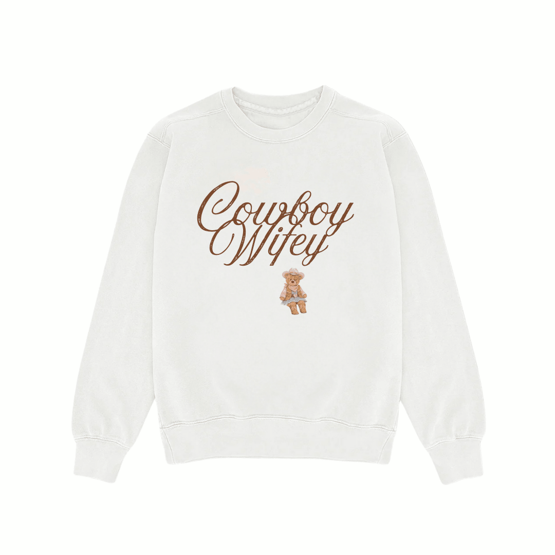 White crewneck sweatshirt with “Cowboy Wifey” graphic and small baby illustration