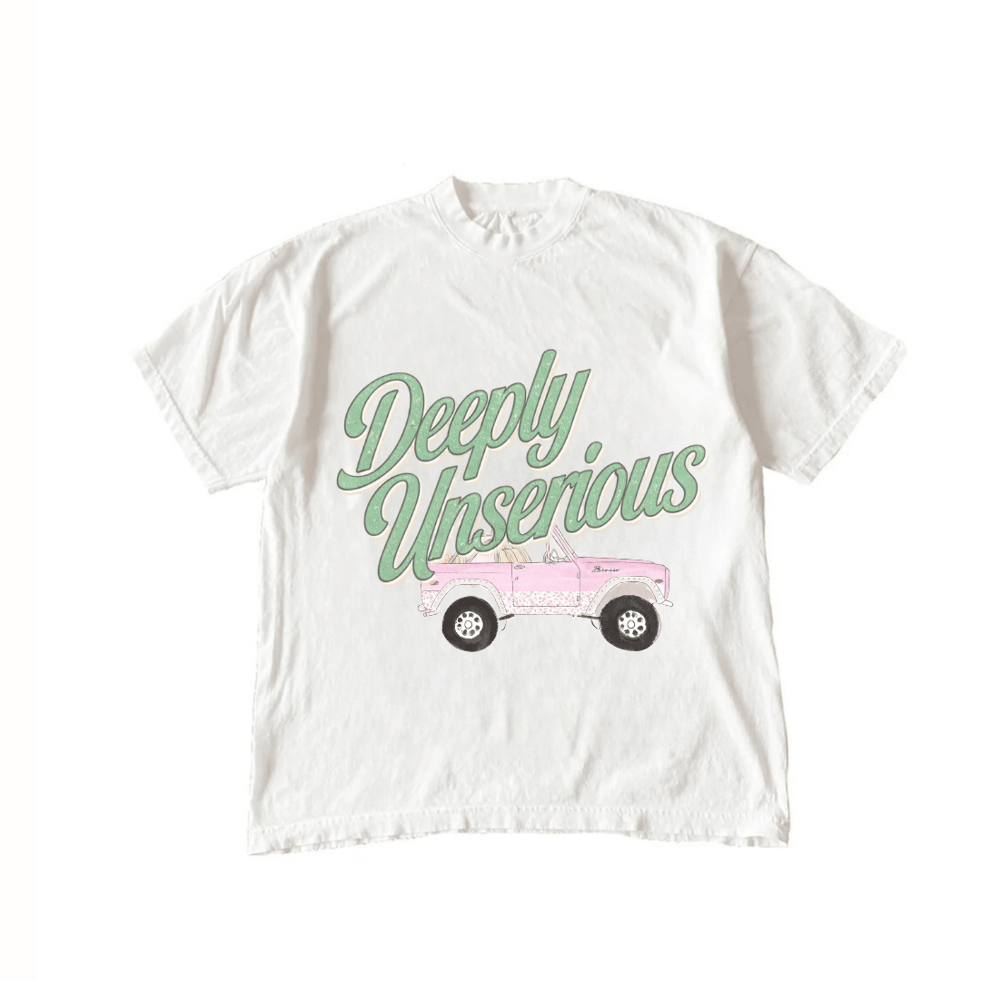 White T-shirt front graphic with green “Deeply Unserious” lettering and pink vehicle