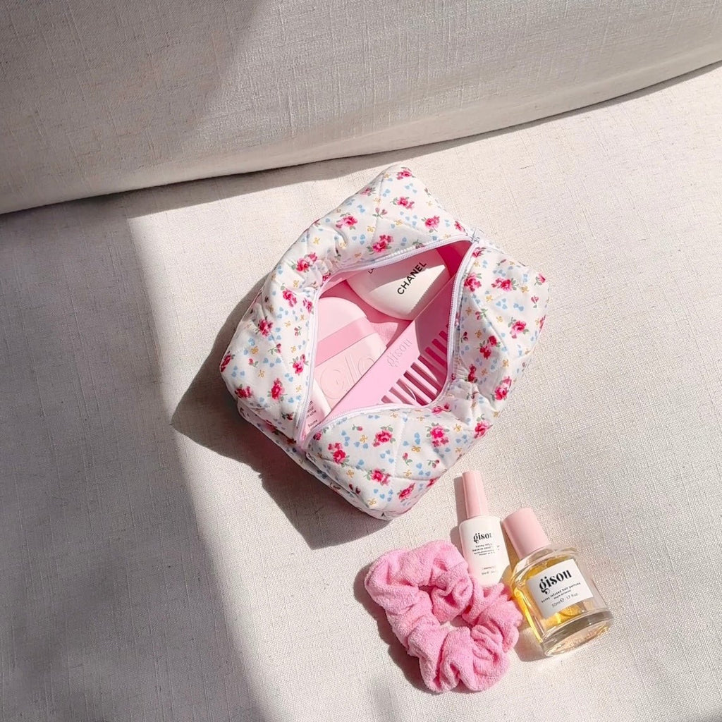 White floral padded zip pouch, open top with front zipper and pink items inside