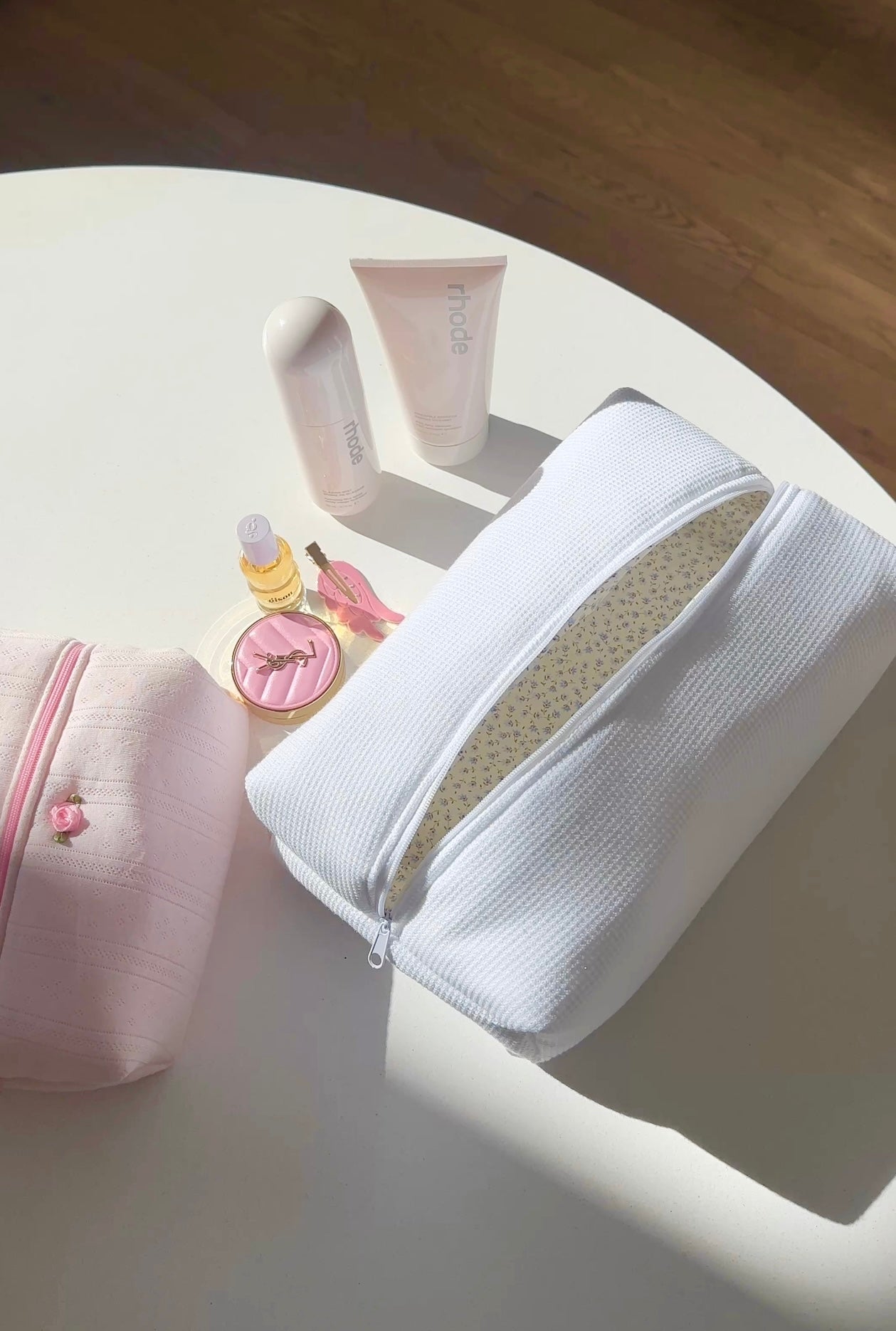 White waffle-knit zip pouch open, showing contents and zipper edge