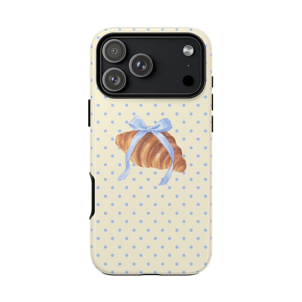 Cream phone case with blue dotted pattern and centered bow on croissant graphic