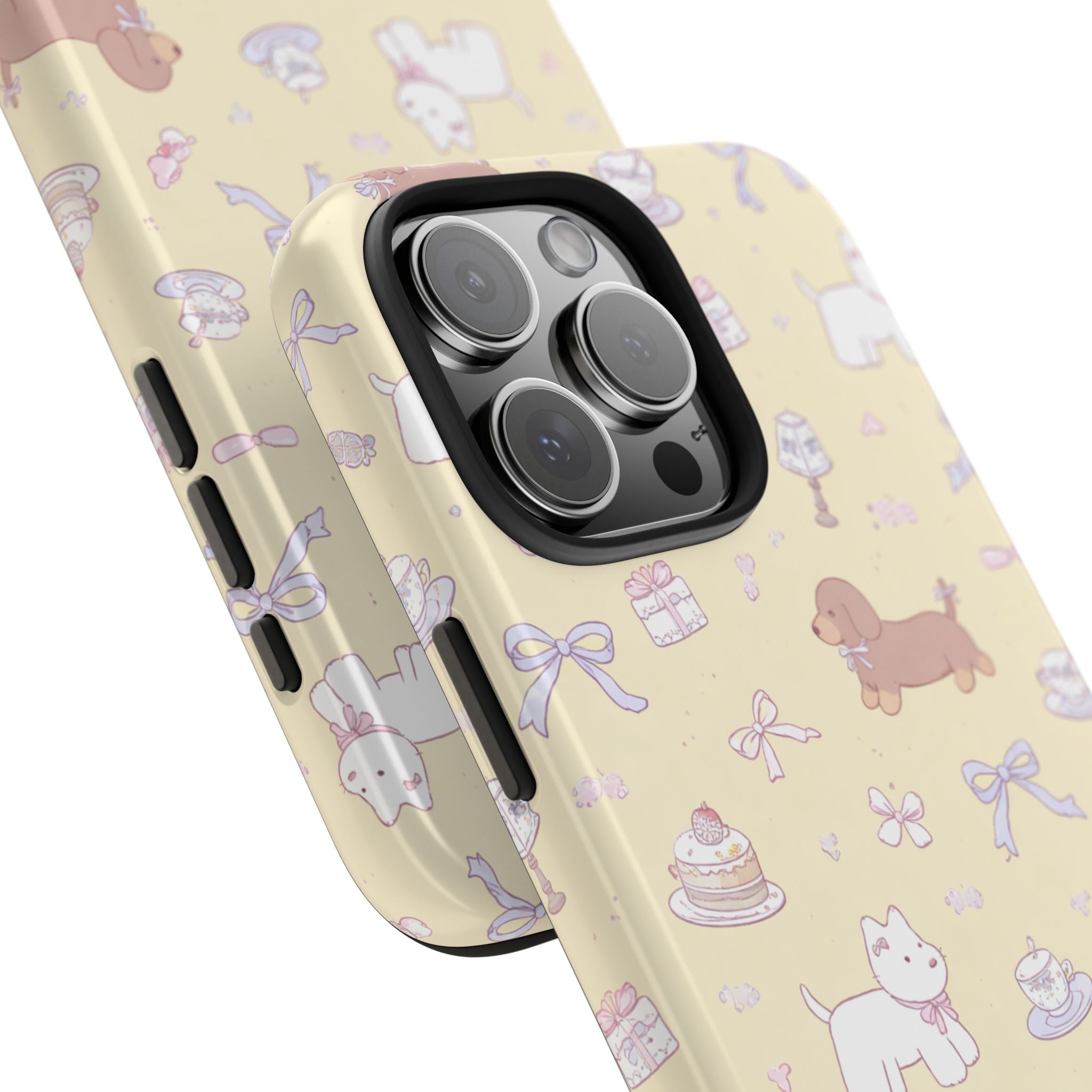 Angled close-up of yellow coquette pet phone case with camera cutout and bows, cakes, and cat figures.