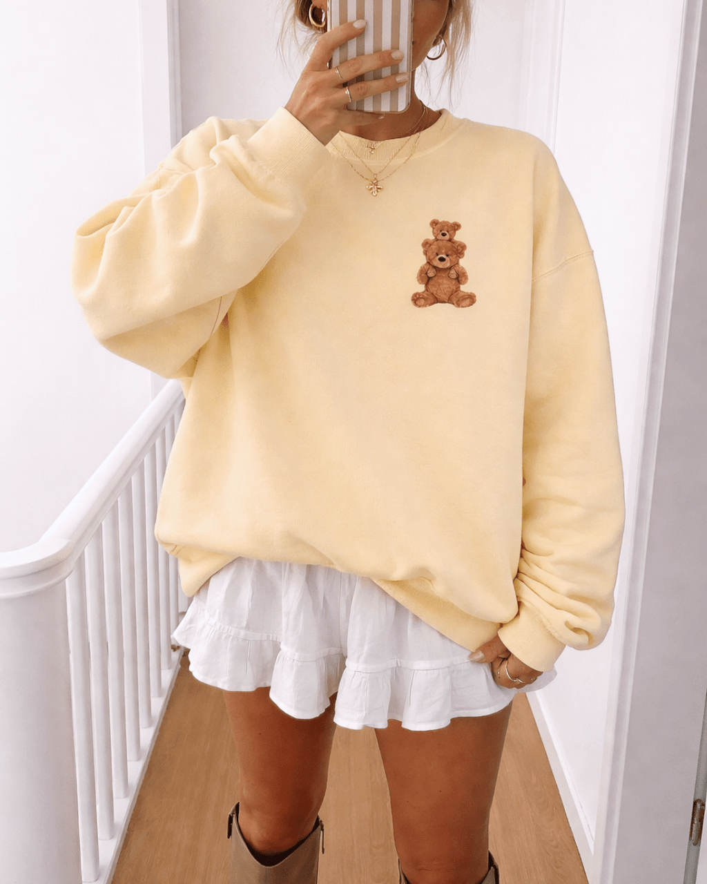 Light yellow crewneck sweatshirt with teddy bear graphic on chest, oversized sleeves