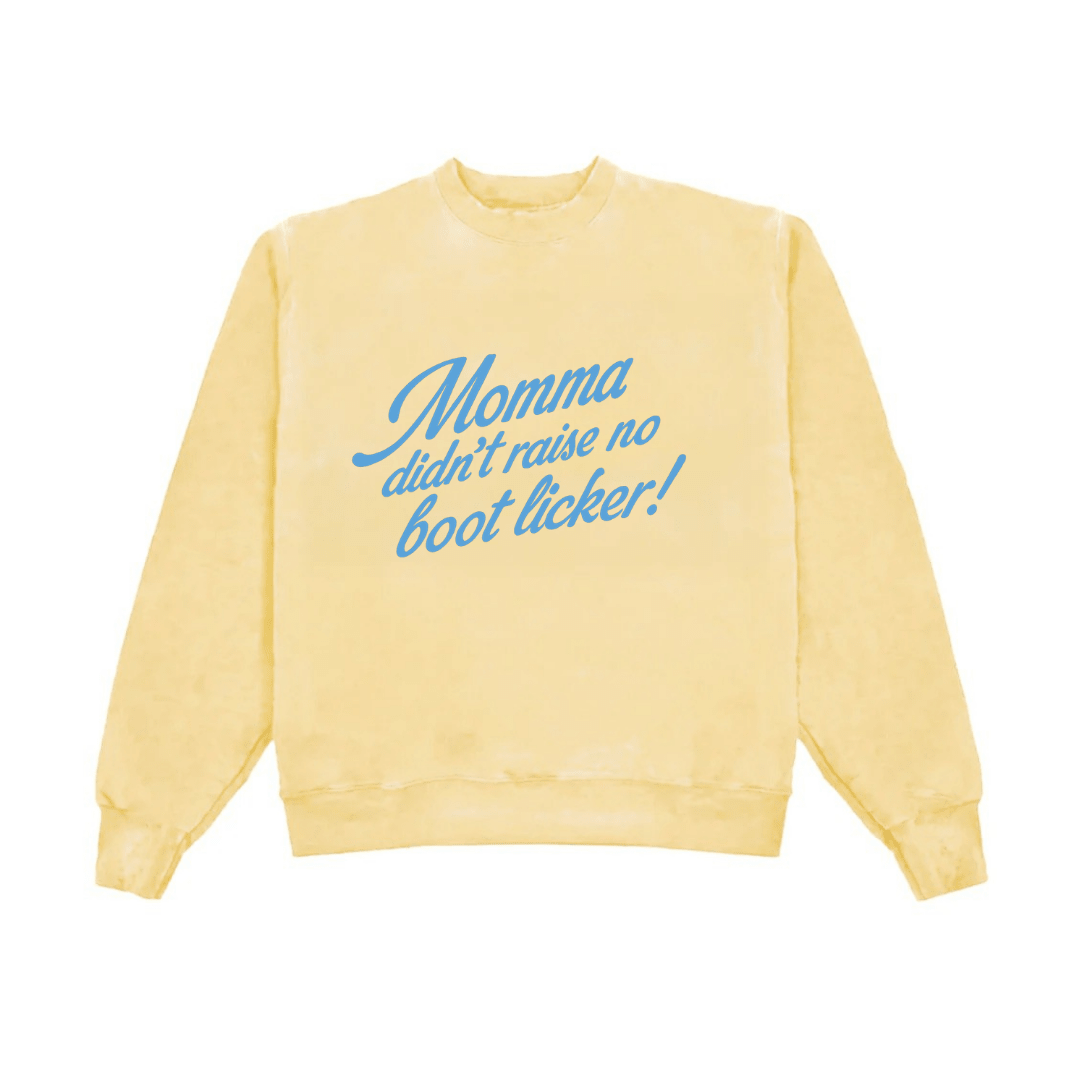 Yellow crewneck sweatshirt with blue slogan: Momma didn’t raise no boot licker!