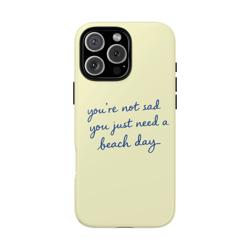 Light yellow phone case with blue text “you’re not sad, you just need a beach day”.