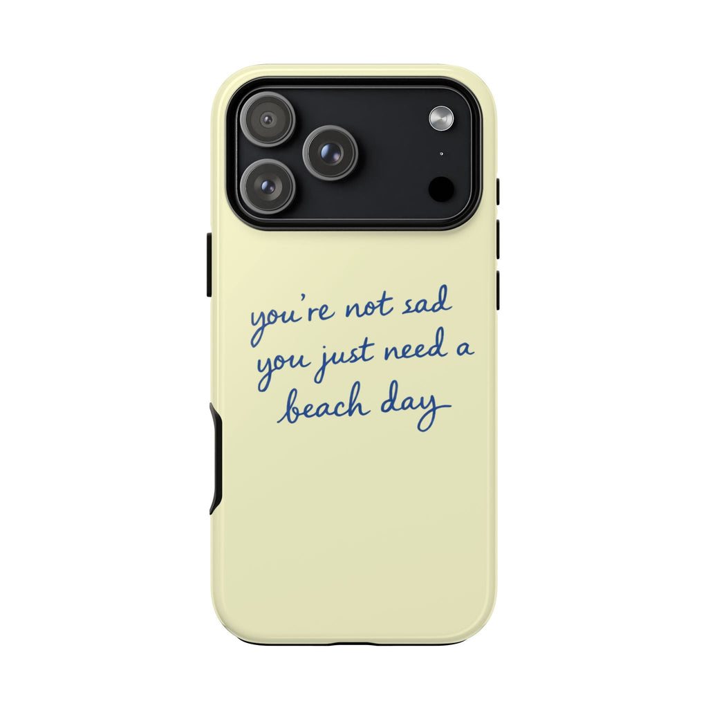 Light yellow phone case with blue “beach day” quote beneath the camera cutout.