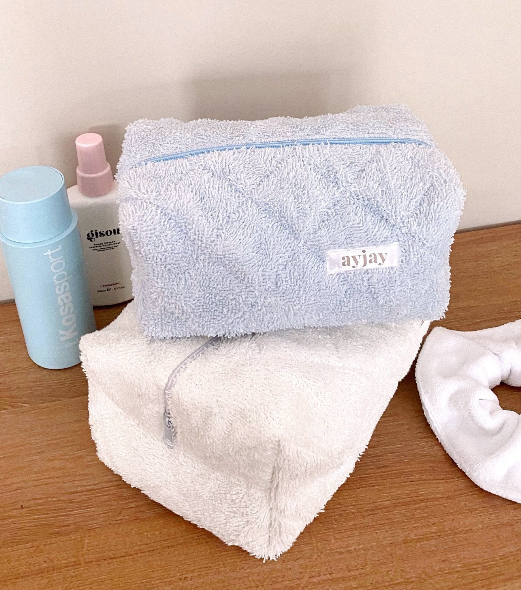 Baby blue terrycloth zip pouch with logo patch, plus white terrycloth heart pouch