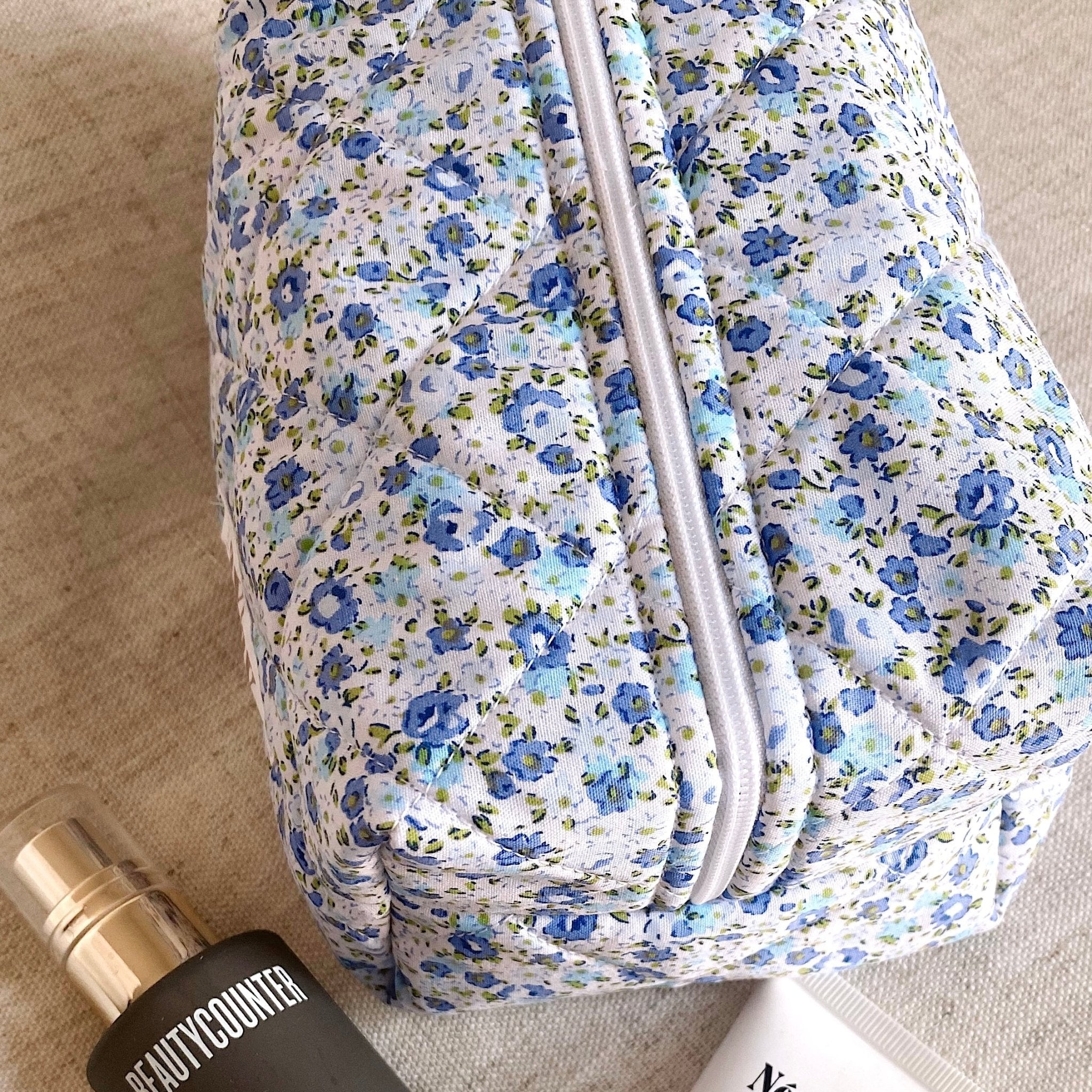 Close-up of blue floral zippered pouch fabric and zipper
