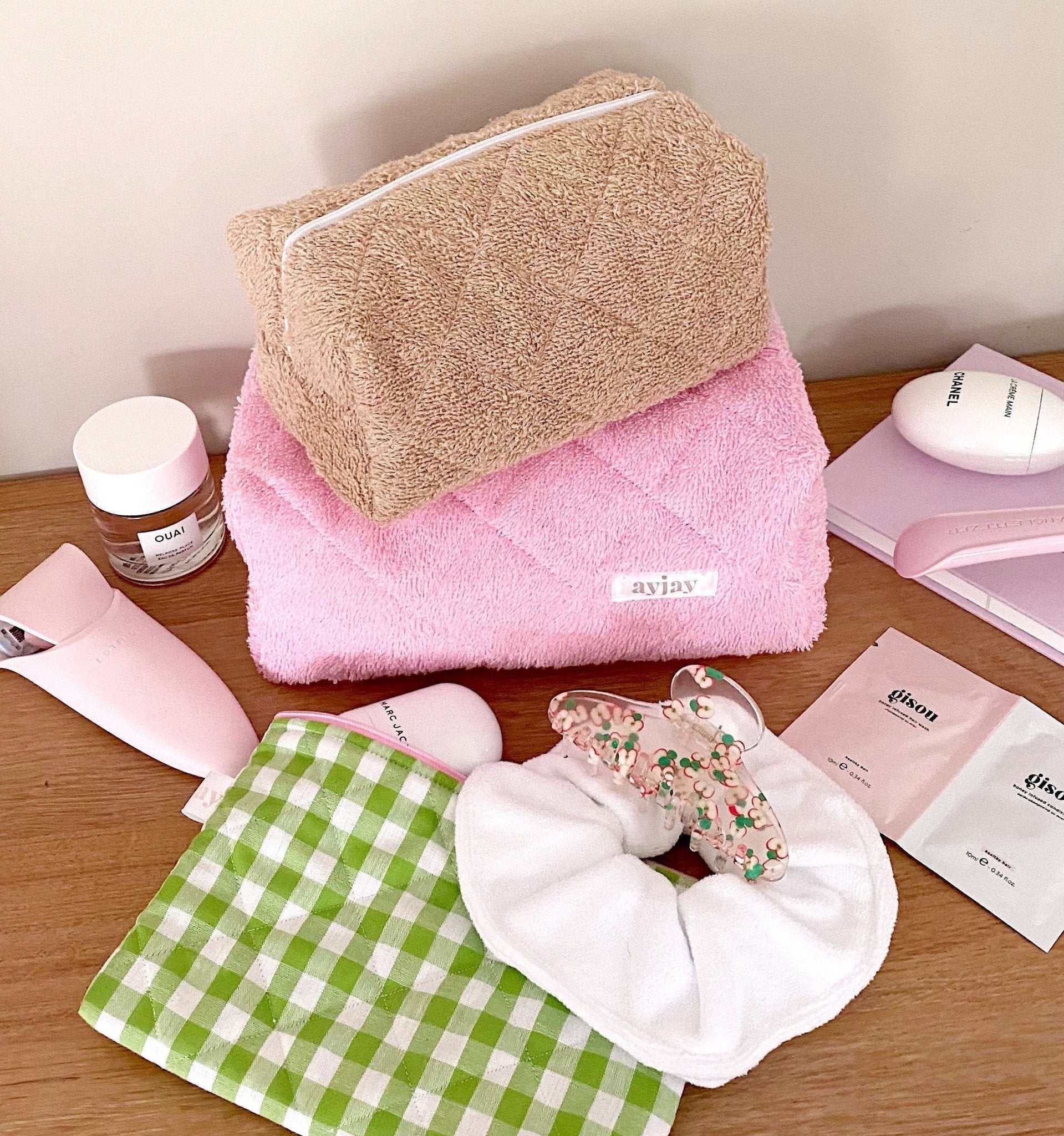 Brown teddy pouch with zip and light trim, shown folded with soft pastel items nearby