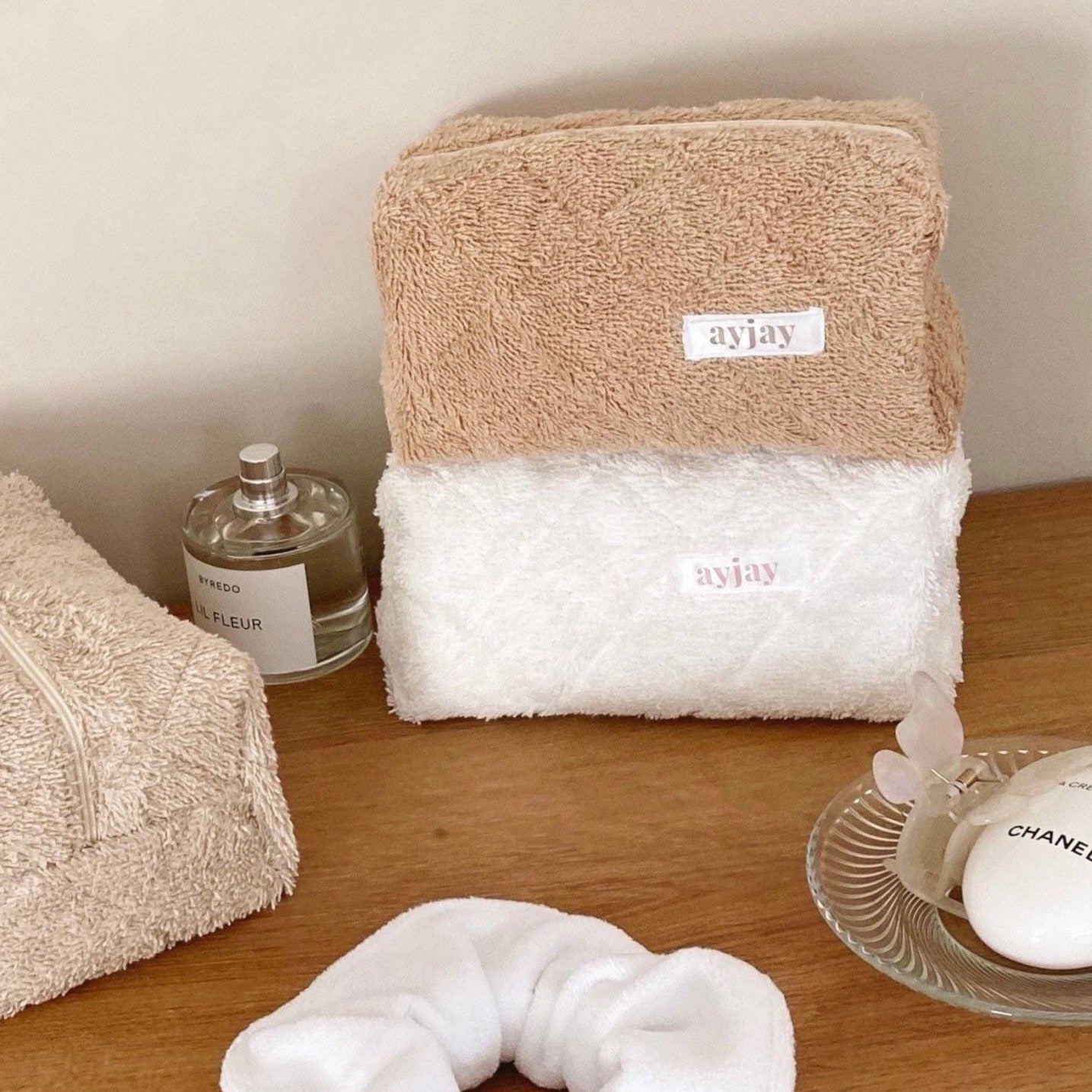 Tan terrycloth and white terry pouch with zip closure and front label patch