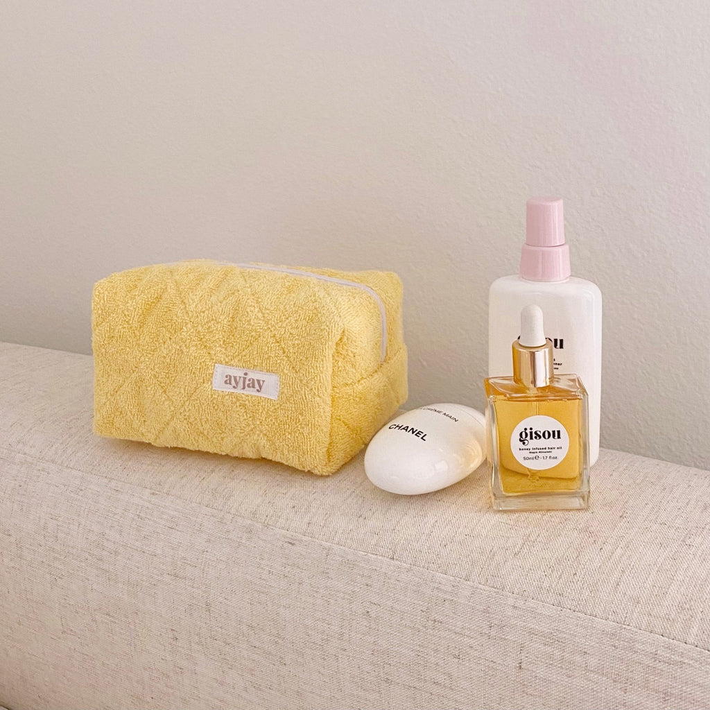Butter yellow terrycloth cosmetic pouch with top zipper and rectangular shape
