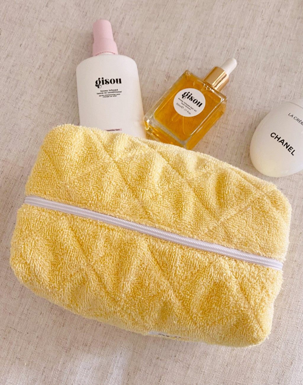 Butter yellow terrycloth flat zip pouch with textured surface and white zipper