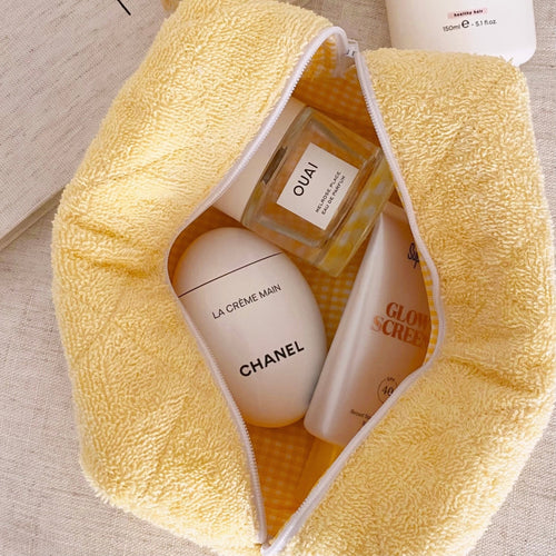 Open butter yellow terrycloth zip pouch with white zipper and textured lining