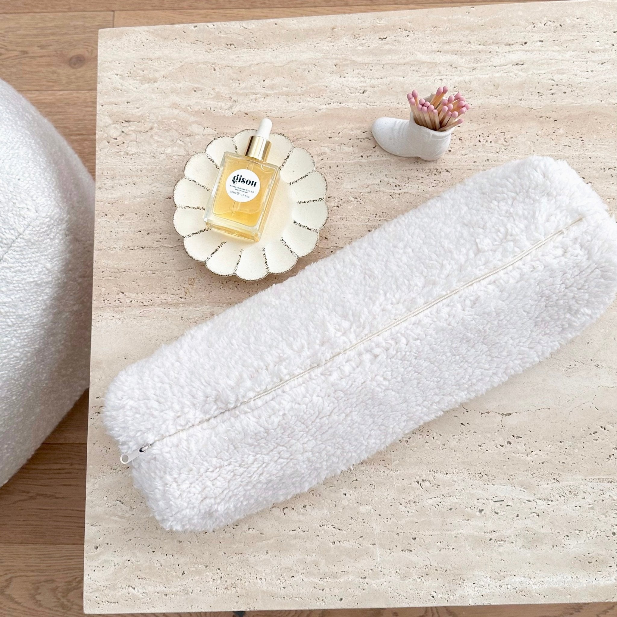 Cream soft teddy long pouch with zipper and chain, flat on surface