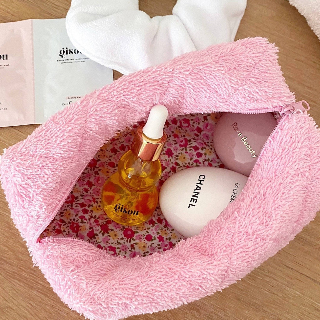 Open pink fuzzy makeup bag with rose floral lining and visible zipper