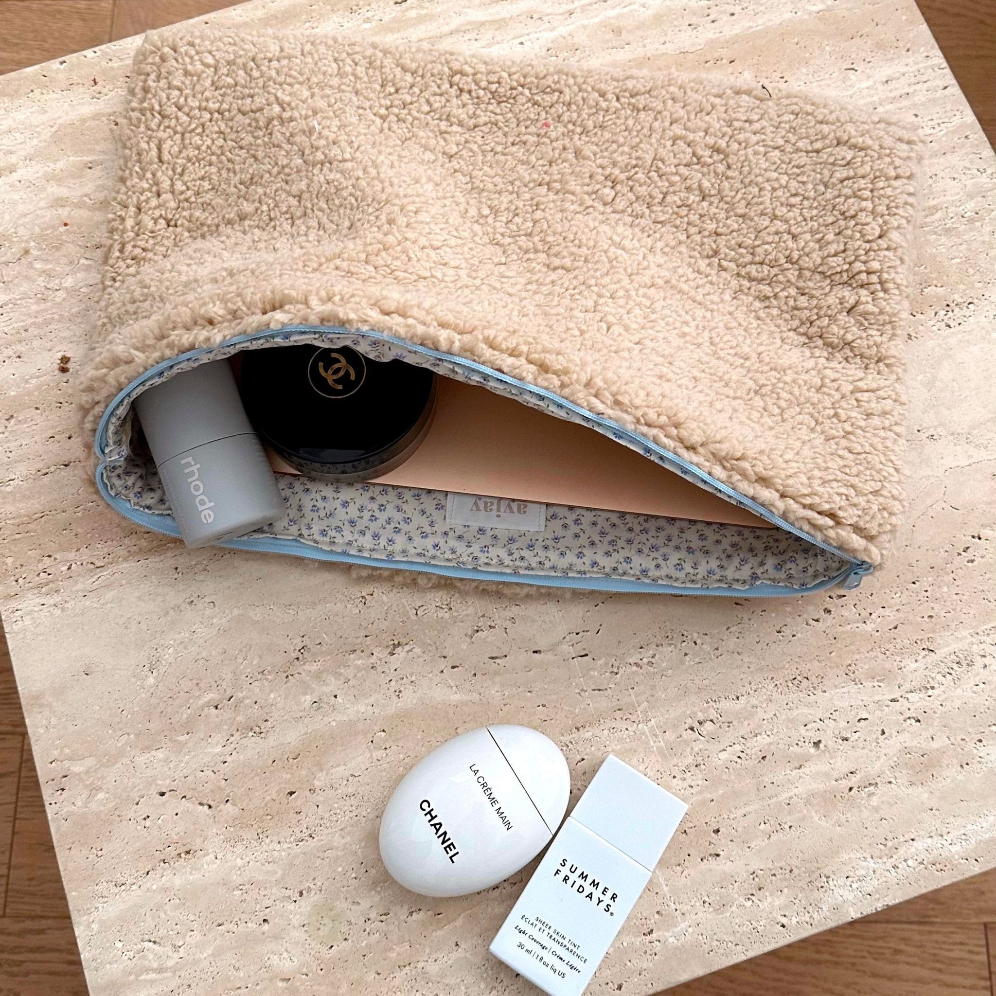 Sherpa pouch with blue trim, open to show containers and a small pouch