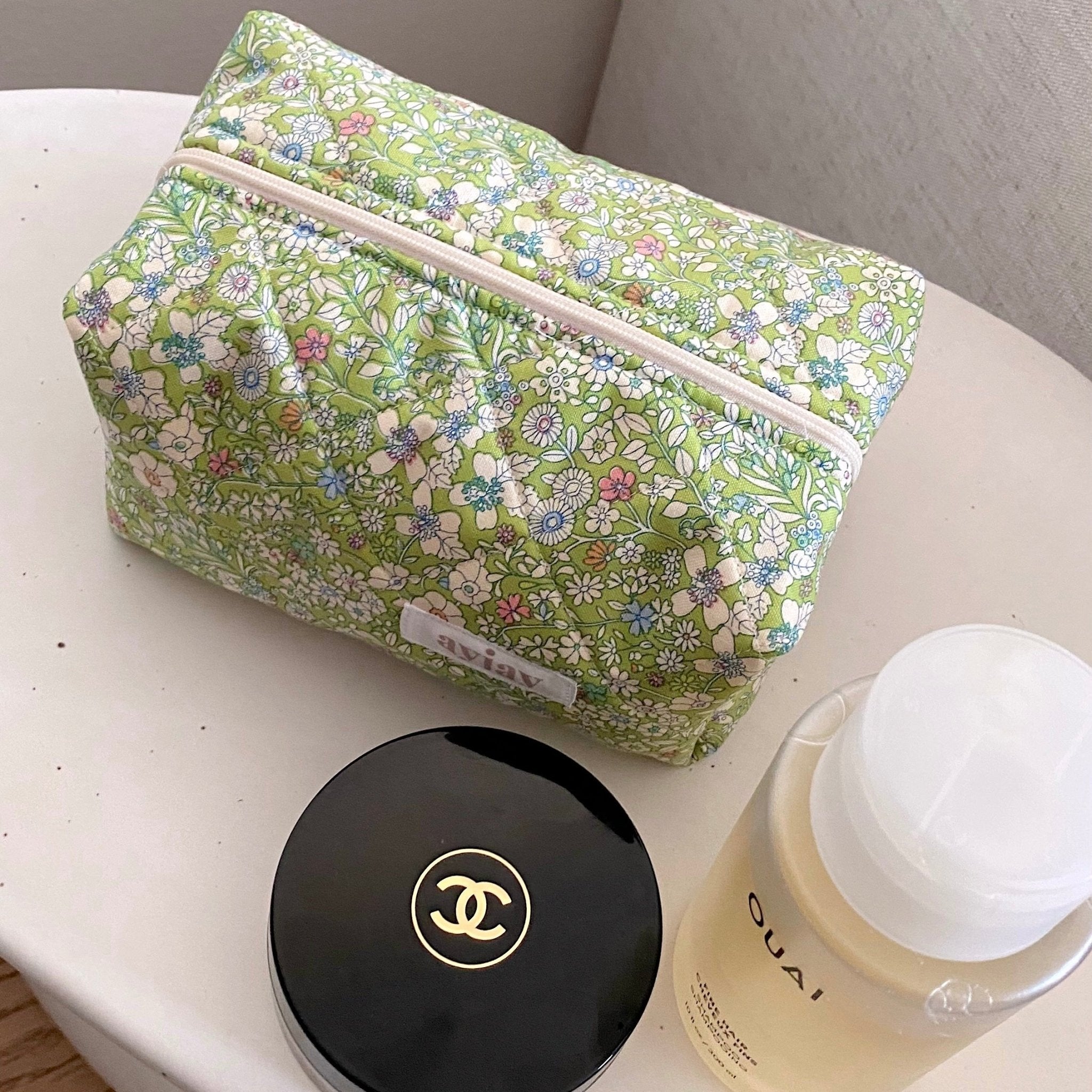Green floral zip cosmetic pouch with long horizontal zipper