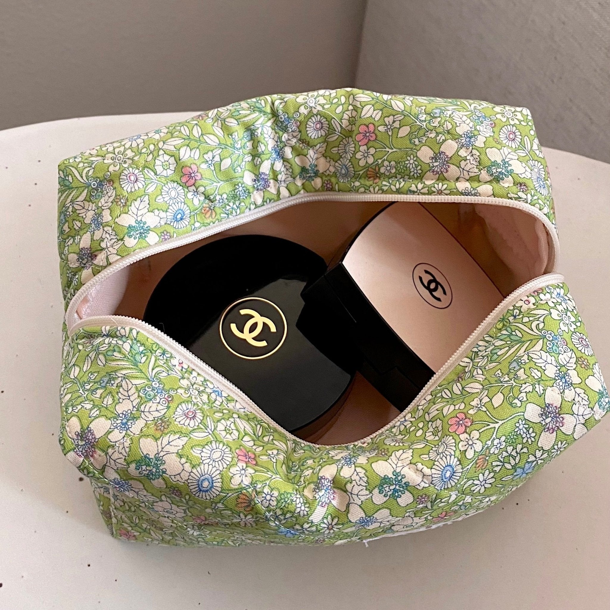 Open green floral zip pouch with interior visible