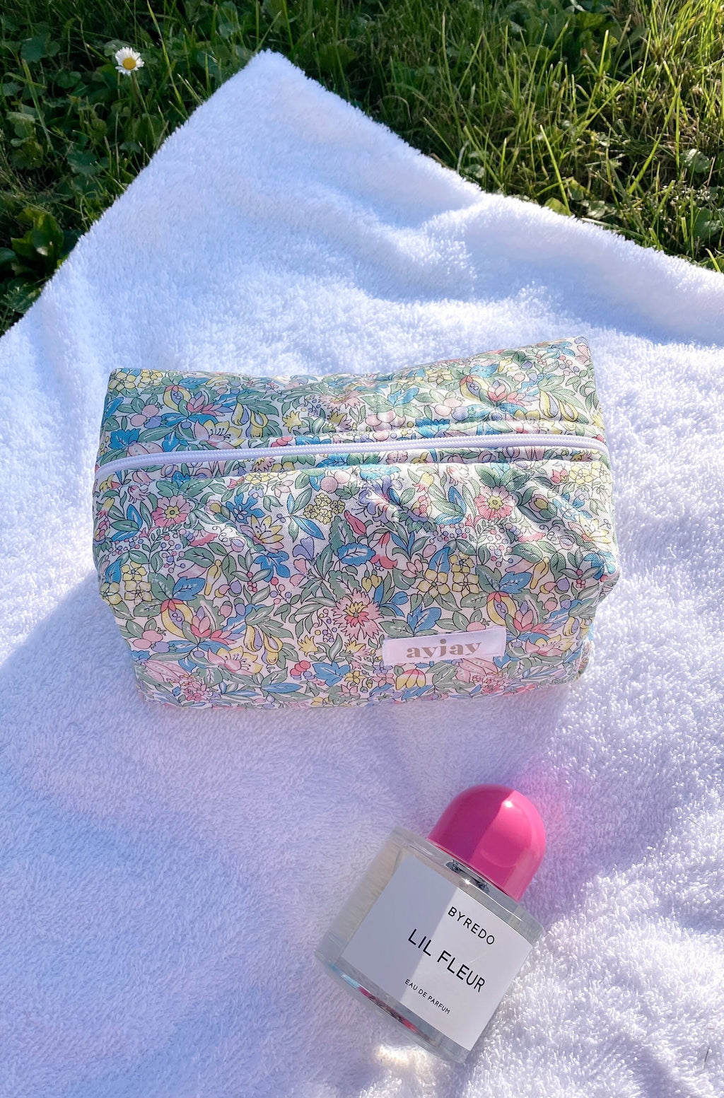 Floral zip pouch with multicolor blossoms, zipper closed, pink gingham interior edge
