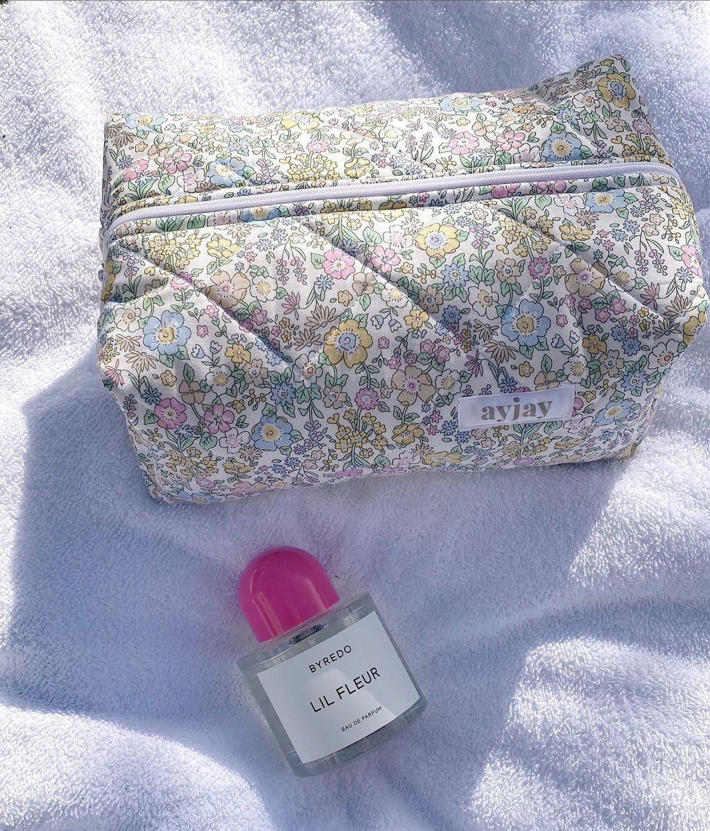 Pastel floral makeup bag with front zipper panel and small logo patch