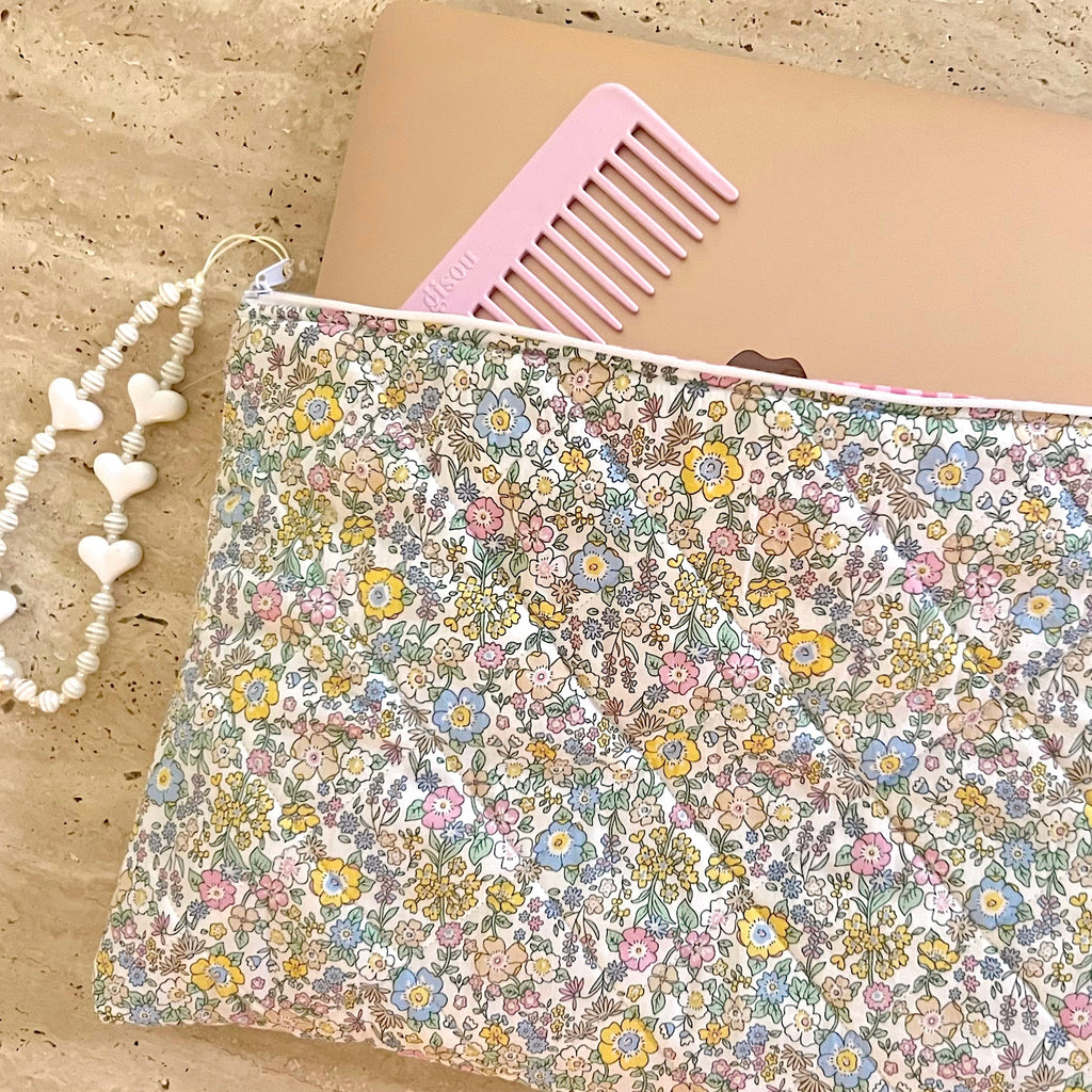 Floral laptop sleeve with pink comb top edge and stitched fabric lining detail