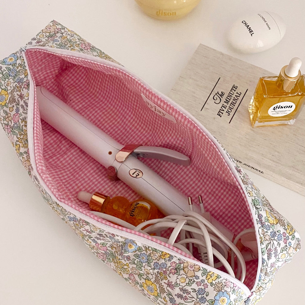 Floral hair tool pouch with pink gingham lining, showing white hair tool and cable