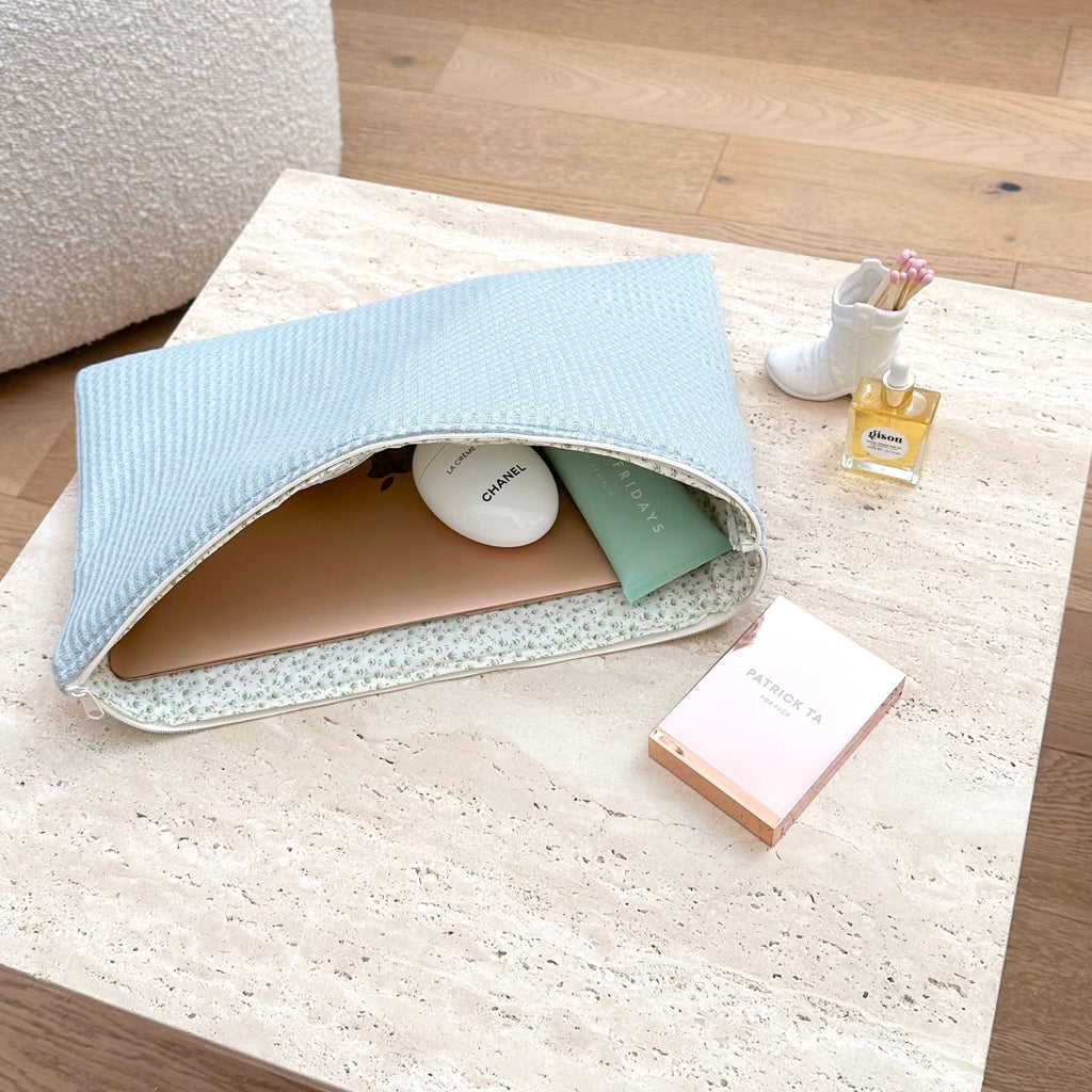 Light blue waffle knit zip pouch, open top showing inner pockets.