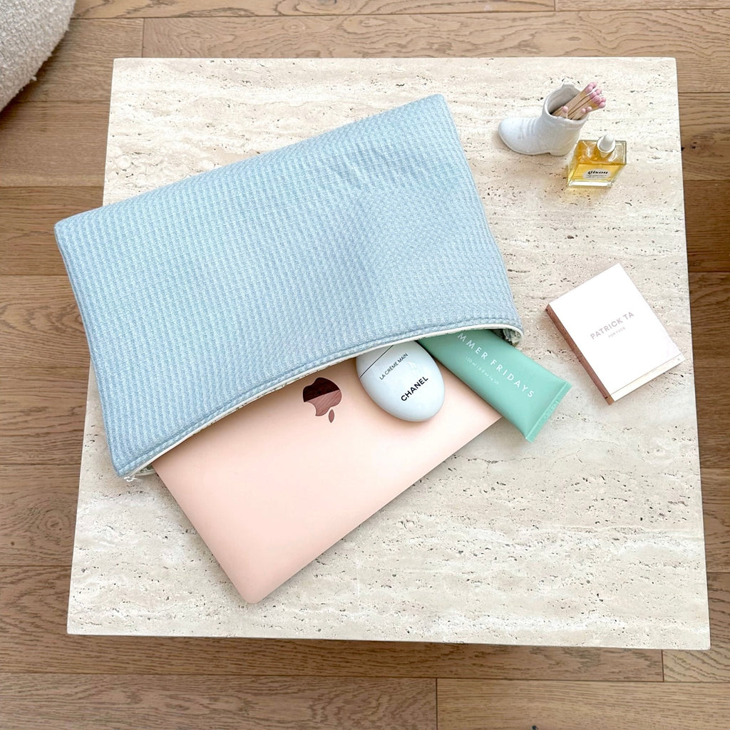 Light blue waffle knit zip pouch, open top with inner compartments visible.