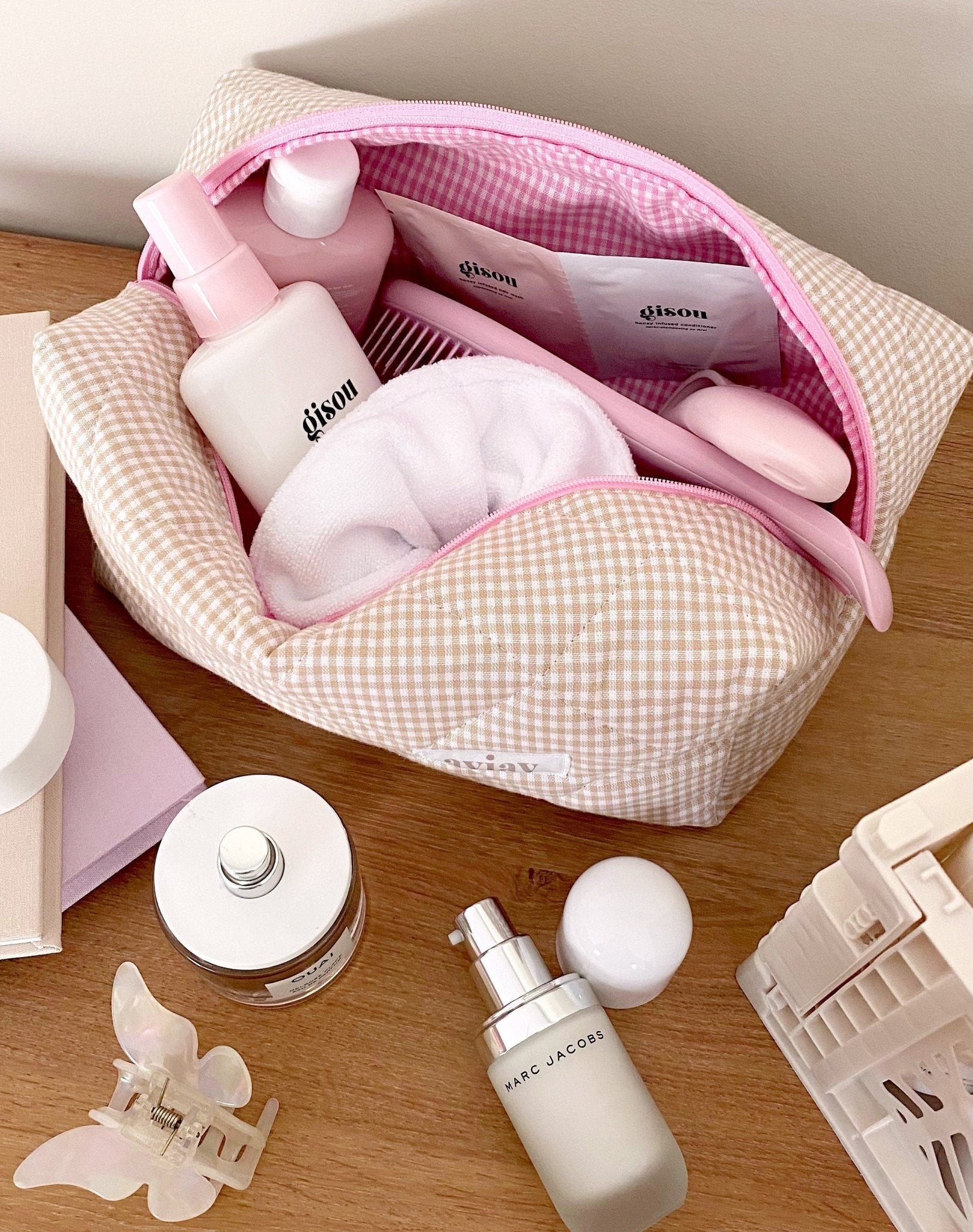 Open brown gingham toiletry pouch with pink trim and zip top, interior visible