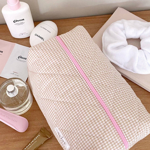 Brown gingham toiletry pouch with pink zipper and piping, angled view