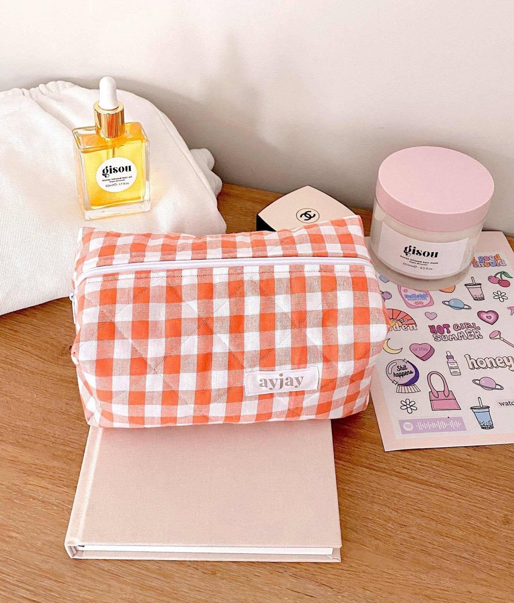 Orange gingham zip pouch with white piping and rounded top edge