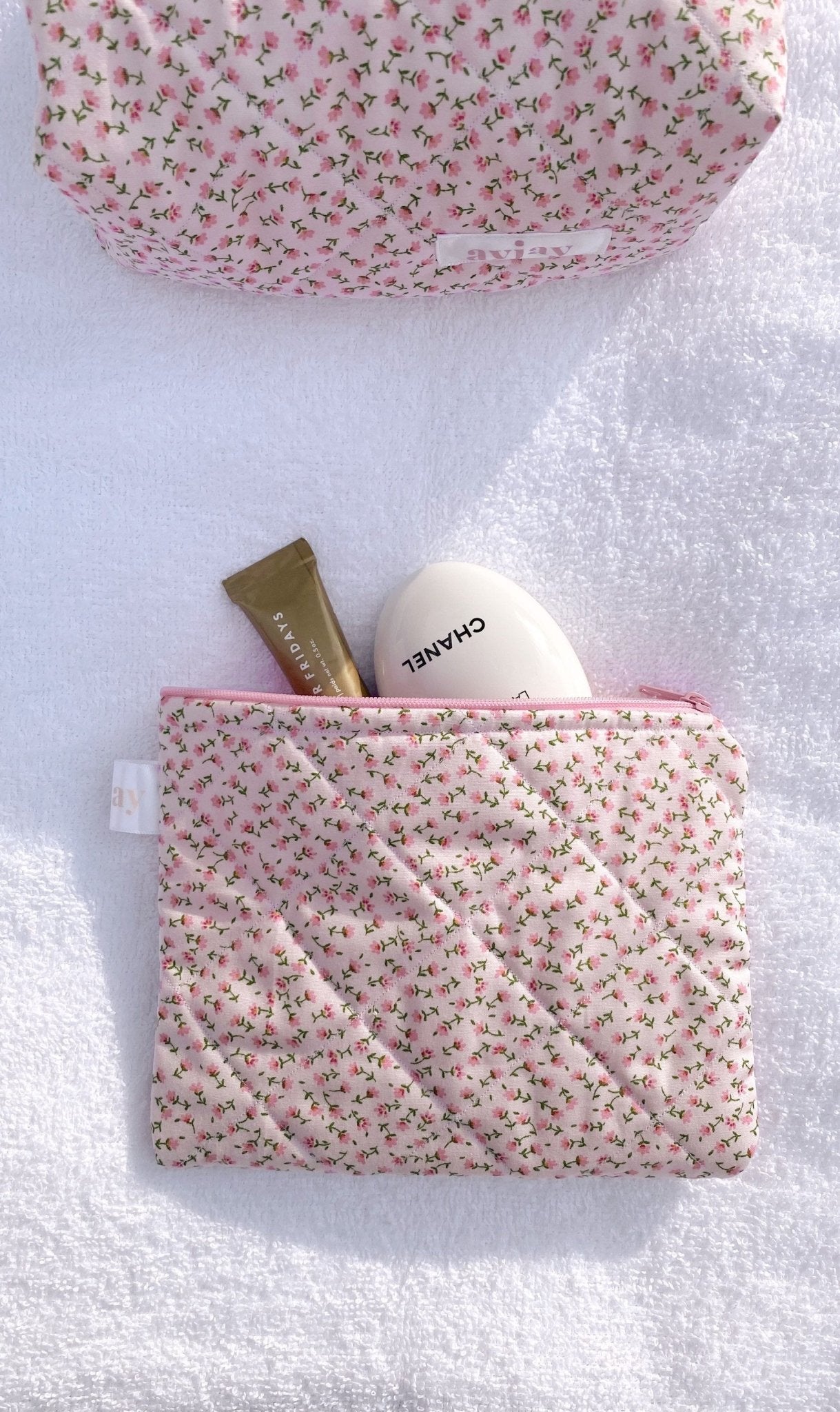 Pink ditsy floral rectangular zip pouch with pink zipper and internal items