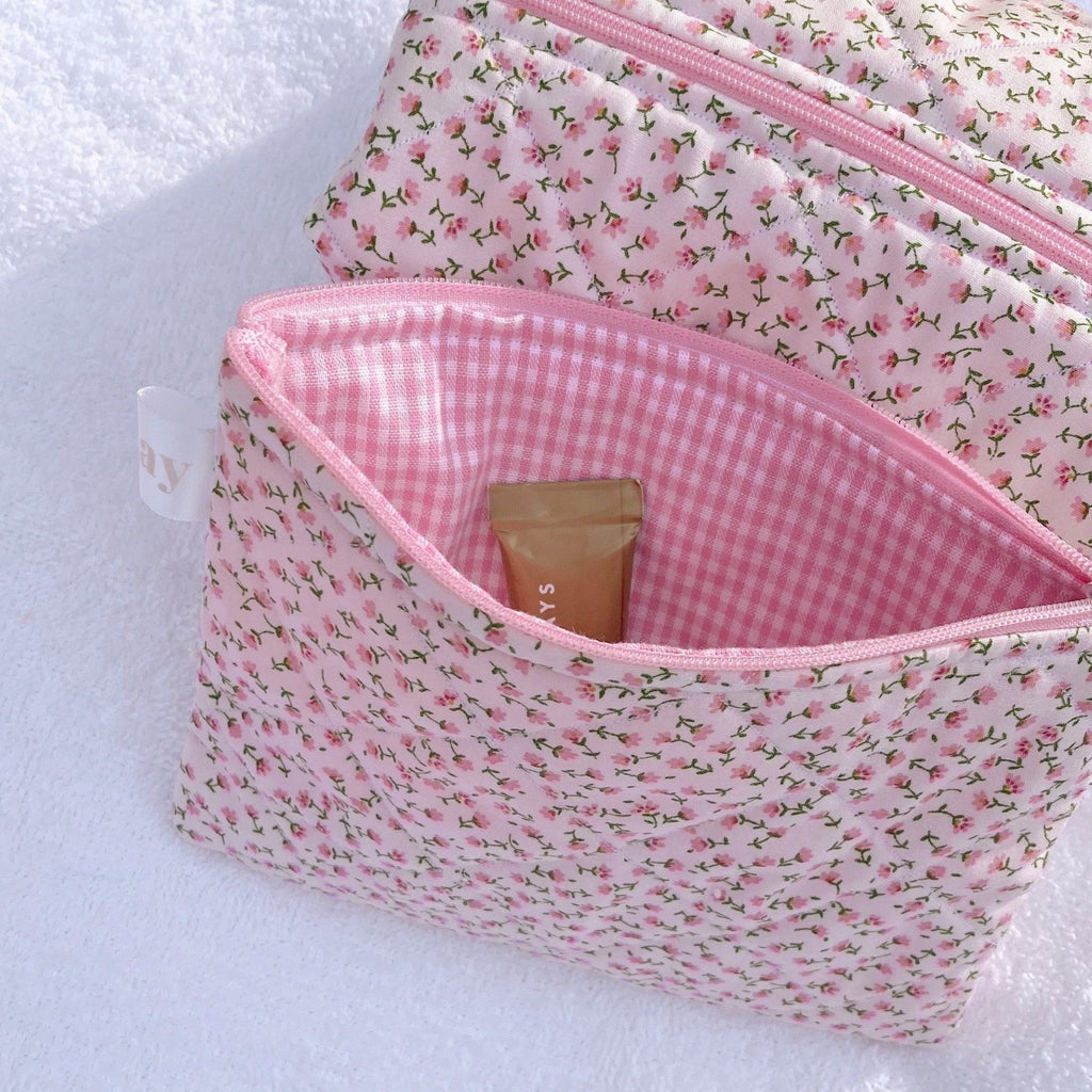Pink ditsy floral cosmetic pouch with pink gingham interior lining and zip opening.