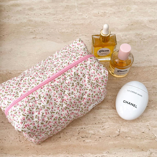 Pink floral zip pouch with pink zipper trim and rounded rectangular shape