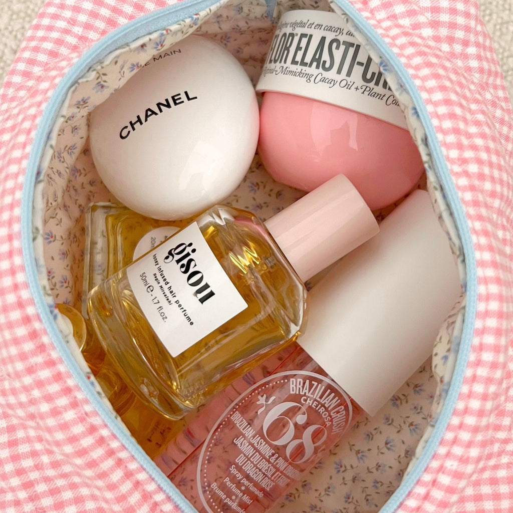 Pink gingham pouch interior with blue trim, filled with beauty products