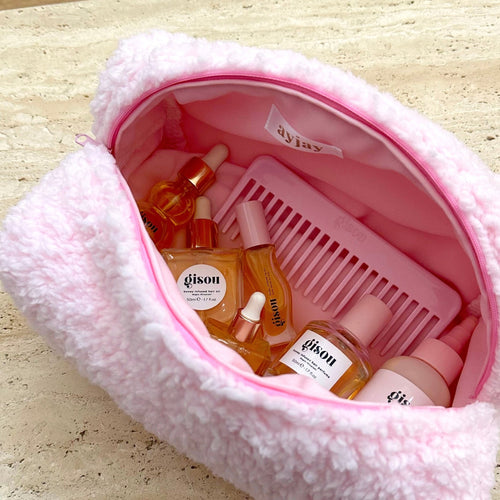 Light pink soft teddy zip pouch, open top showing toiletries and comb inside