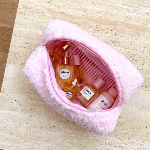 Light pink soft teddy zip pouch, open view showing bottles and comb slots inside