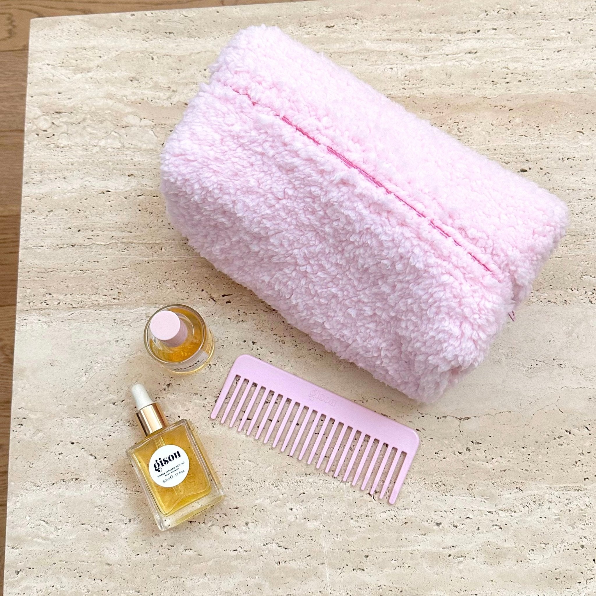 Light pink soft teddy zip pouch, closed with a centered pink zipper