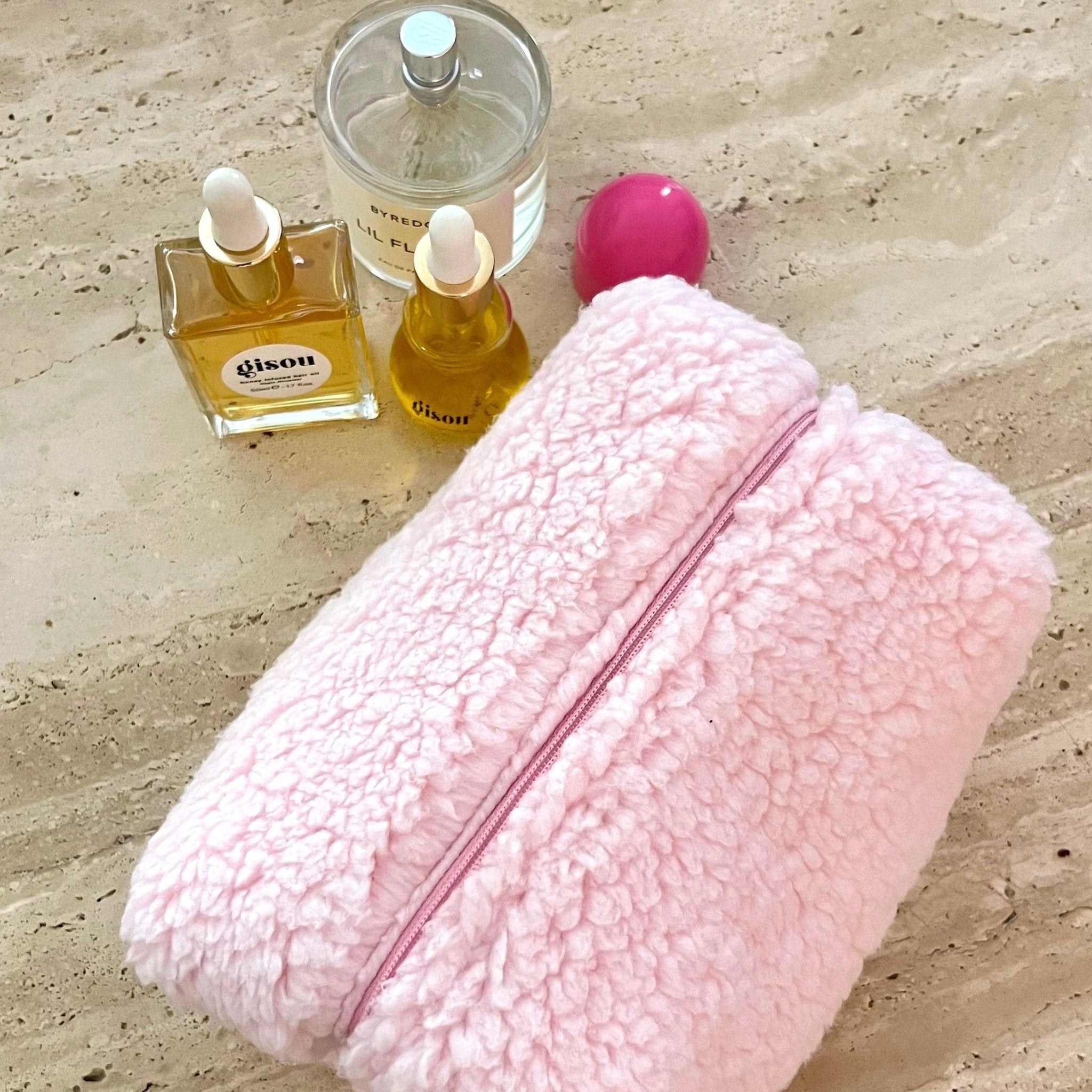 Pink teddy zip pouch with strawberry-lined interior, shown from side.